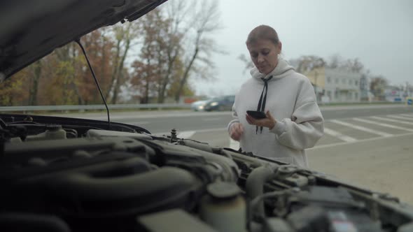 Woman Wtanding At Broken Car Searching For Repair Service