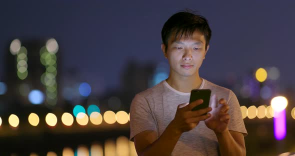 Man use of mobile phone in the city at night