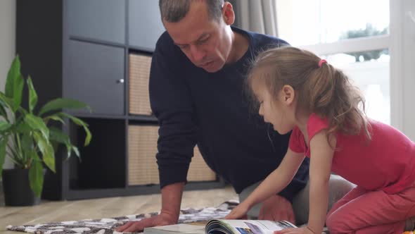 A Father Reads a Book to a Child