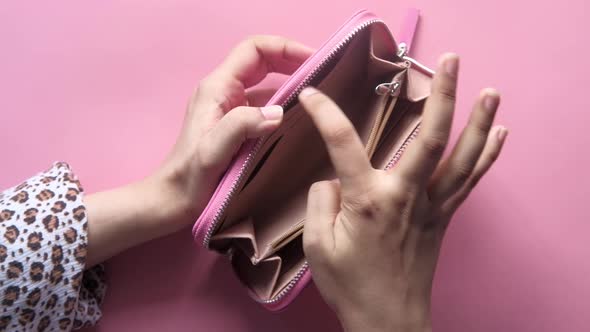  Women Hand Open an Empty Wallet on Pink Background 