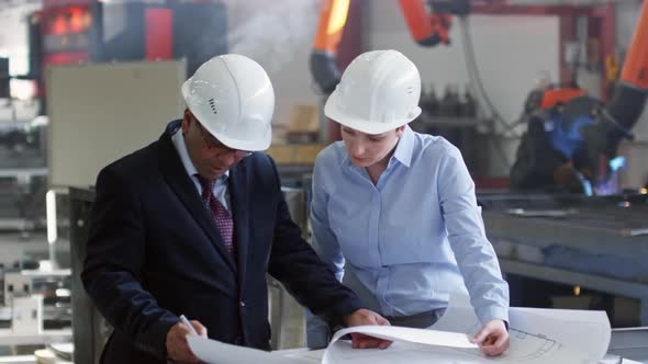 Male and Female Engineers Working on Architectural Plan