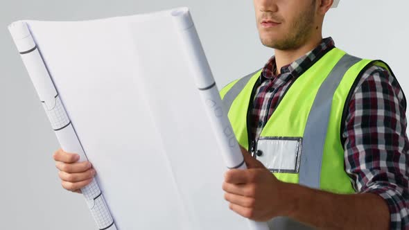 Male architect looking at blueprint against white background 4K 4k