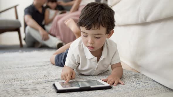 Sweet Little Boy with Tablet Lying on Floor in Living Room