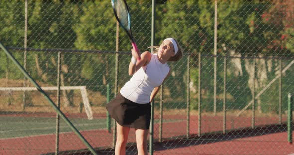 Video of happy caucasian female tennis player holding racket and hitting ball