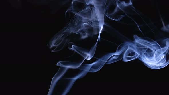 A Jet of White Smoke Rises Up Against a Black Background