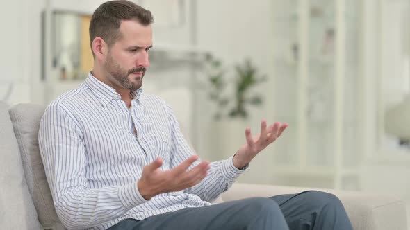 Worried Young Man with Headache Sitting at Home