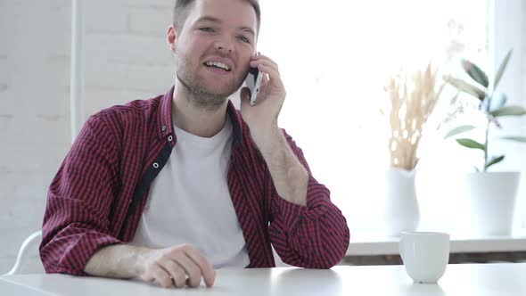 Young Man Talking on Phone in Office