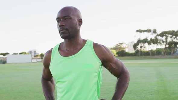 Fit african american man exercising outdoors stretching from the waist