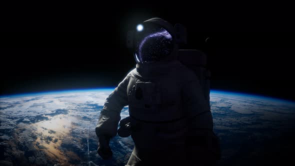 Astronaut in Outer Space Against the Backdrop of the Planet Earth