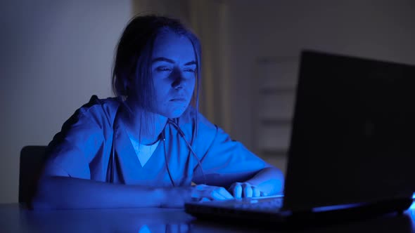 Overworked Female Nurse Sobbing Sitting in Front Laptop in Dark Room, Stress