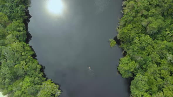 drone footage of woman swimming in black water lake