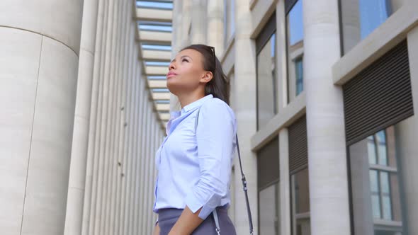 Happy Afroamerican Businesswoman Looking Up Standing Outside Business Center