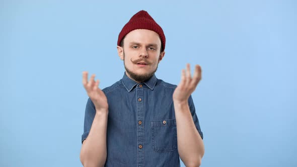 Portrait of Hipster Man 20s Wearing Hat and Denim Shirt Expressing Boredom or Cant Help with Gesture