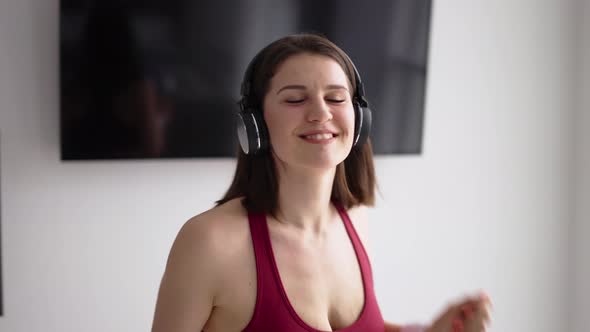 Happy Brunette Woman in Headphones Dancing at Home