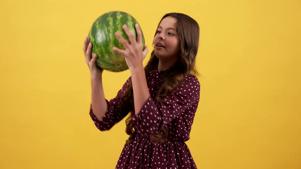 Amazed Kid Taking Heavy Watermelon Fruit on Yellow Background Fruit