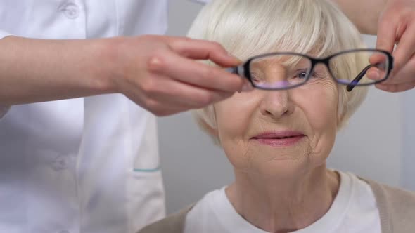 Doctor Giving Eyeglasses to Happy Elderly Woman With Vision Problems, Health