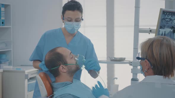 Oral Care Worker Giving Oxygen Mask with Anesthesic to Patient