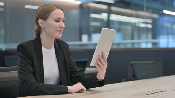 Video Call on Tablet By Beautiful Businesswoman at Work