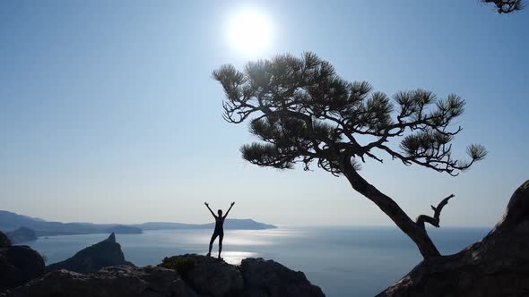 Female Tourist Athlete Climbed To the Top of the Cliff and Enjoys the Beautiful Scenery and Views of