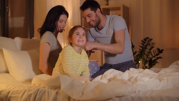 Father Braiding Daughter Hair in Bed at Home 24