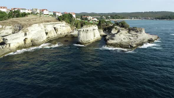 Rocks in The Sea And People Standing On It 