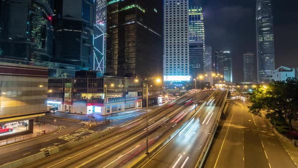 Hong Kong Rush Hour Traffic at Night. Time Lapse of Skyscraper Buildings and Busy Traffic on Highway