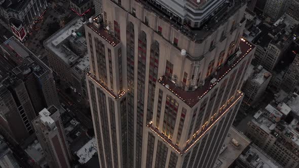 AERIAL: Breathtaking Close Up View of Empire State Building at Dusk with Lights on 