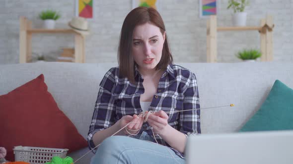 Woman Sitting in Front of a Laptop and Watching a Video Tutorial on Knitting and It Does Not Work
