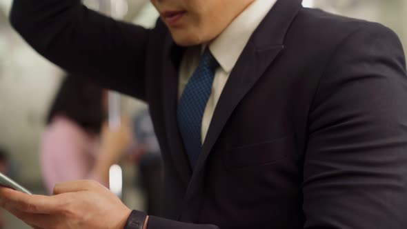 Businessman Using Mobile Phone on Public Train