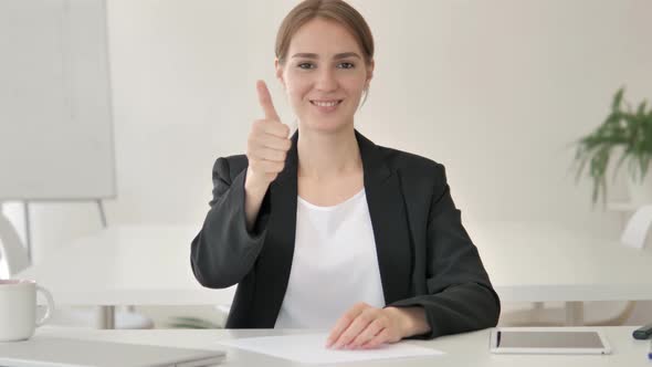 Thumbs Up by Young Businesswoman in Office