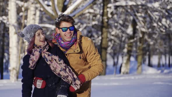 Young Happy Couple Waving Hand to Somebody Winter