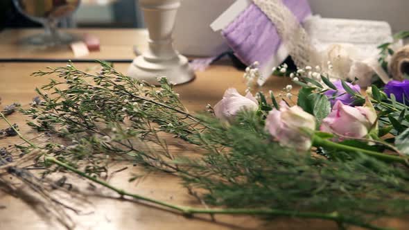 Slow Camera Movement Showing Wooden Table with Flowers Scissors Tapes Decorating Paper and Other