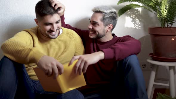 Lgbt Gay Couple Hugging and Reading Book Together Indoor at Home Homosexual Love and Romance Concept