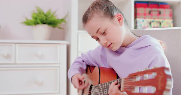 Teen Girl is Playing Guitar and Singing