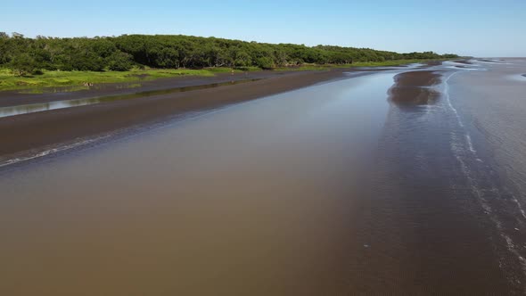 Aerial pan of coast of Rio de la Plata, person sits in chair and waves