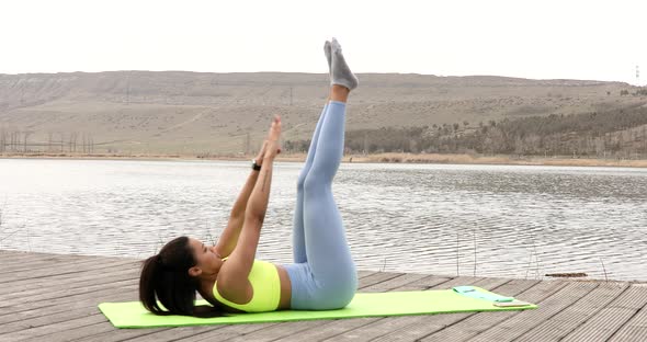 Active fitness young woman working out abdominals.