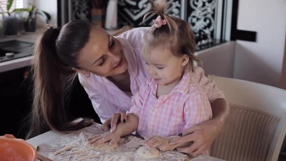 Mother Cooking Together with Little Daughter at Kitchen