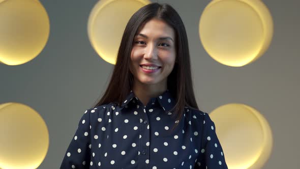 Young Asian Woman in an Elegant Shirt Standing in the Office with a Happy Face Smiling Looking at