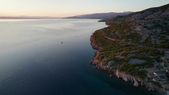 Aerial View of the Rocky Coast of Croatia with a Curve Road at Sunset Time