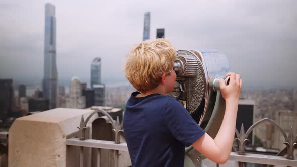 Boy Looking Through Telescope To View New York Skyscrapers