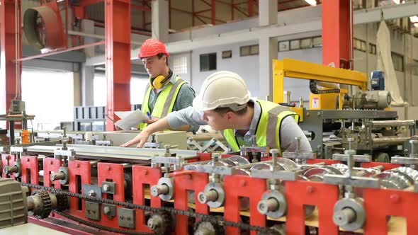 Two young engineers Testing and verifying the operation of the machines