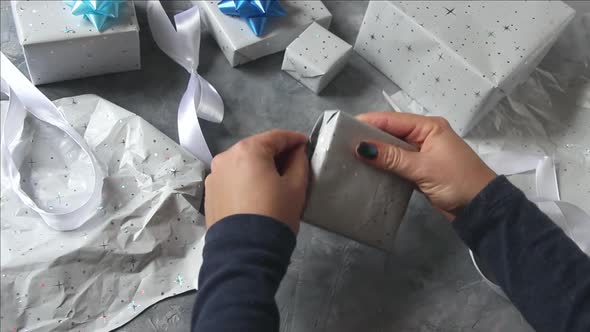 Hands unwrapping present on a table