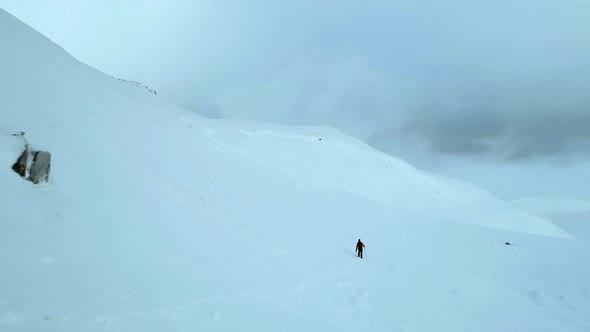 Aerial Flyover of a Mountain Climber in Snowy Conditions