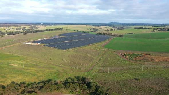 AERIAL Large Solar Farm Located On Green Fields On Sunny Day