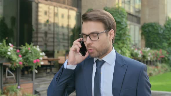 Businessman getting Angry on Call while Walking in Street
