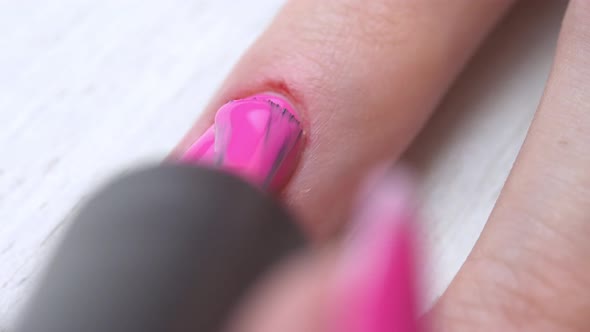 Manicurist Paints Nails with Pink Gel Polish
