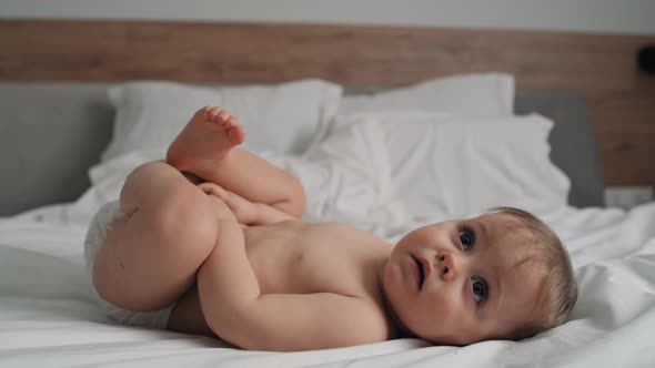 Video of cute little girl after the bath lying on the bed. Shot with RED helium camera in 8K.