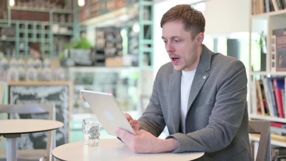 Unsuccessful Young Man Reacting to Loss on Tablet