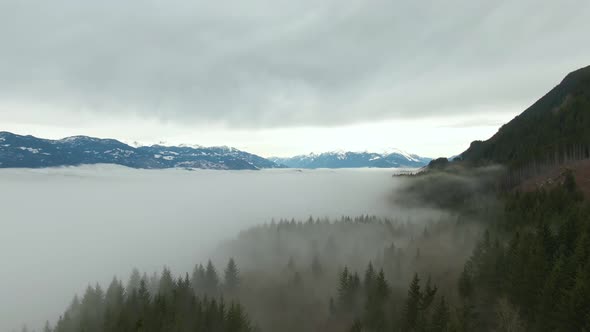 Aerial View of Canadian Mountain Landscape Covered in Fog Over Harrison Lake