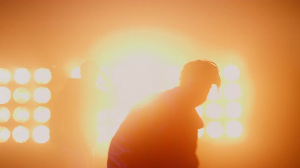 Dancing Men Silhouettes Performing Hip Hop in Bright Spotlights Club Closeup